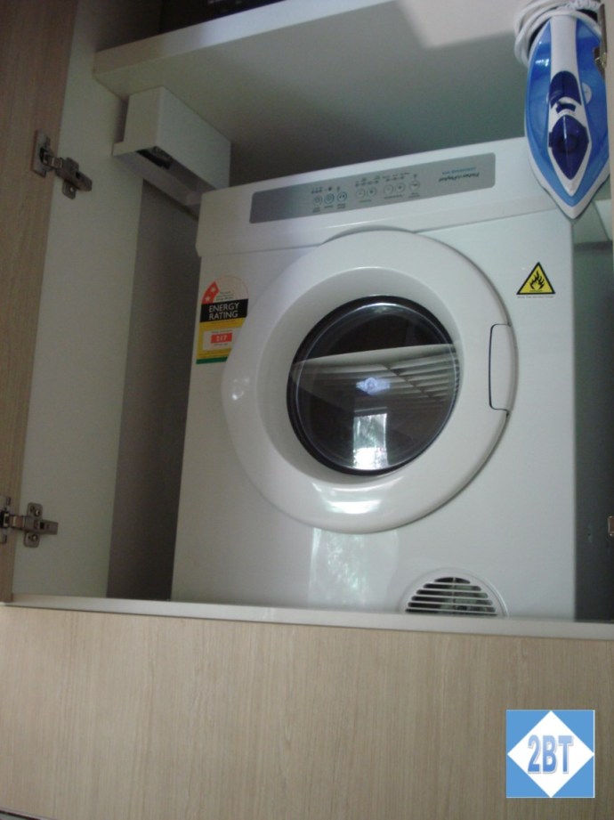 The clothes dryer is up above the fridge in the closet