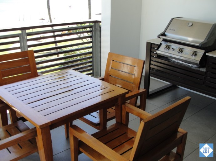 On the balcony: tables, chairs and a grill